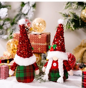 Dettaglio degli gnomi di Natale con paillettes rosse e tessuto a quadri verdi festivo