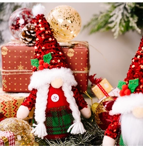 Dettaglio dello gnomo di Natale con cappello rosso di paillettes e foglie di agrifoglio