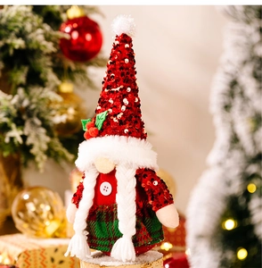 Dettaglio di uno gnomo di Natale con cappello rosso di paillettes, pompon e agrifoglio