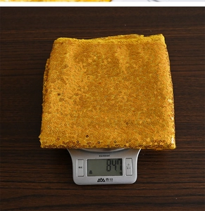 Dettaglio del runner da tavola con paillettes dorate del peso di 847g sulla bilancia