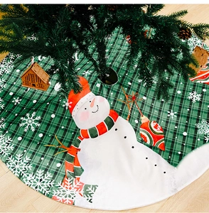 Detailaufnahme der grün-karierten Weihnachtsbaumdecke mit Schneemann- und Schneeflocken