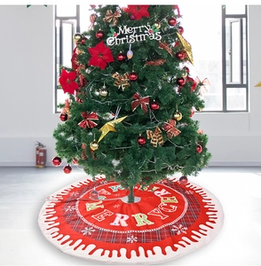 Detail of red Christmas tree skirt with Merry Christmas text and snowflake patterns