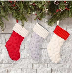 Primer plano de calcetines de Navidad de felpa con textura de rombos, colgados con piñas