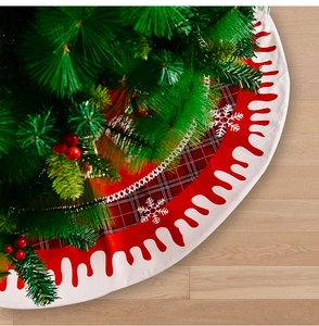 Detail view of red plaid Christmas tree skirt with white snowflakes and wavy trim