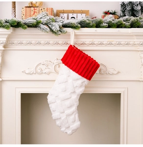 Detalle de calcetín navideño de punto rojo y blanco colgado en una chimenea acogedora