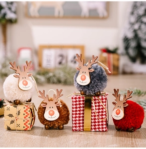 Détail de quatre décorations rennes en peluche colorées dans une scène de Noël festive