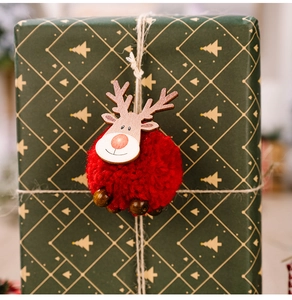 Détail d'un renne en peluche rouge suspendu sur un coffret cadeau de Noël décoratif