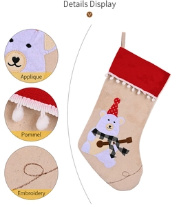 Detail view of burlap Christmas stocking showing pom-pom trim and teddy bear applique