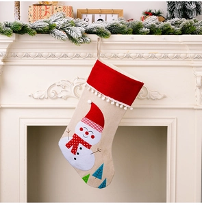 Detail of Christmas stocking with snowman motif hanging on a white fireplace mantle