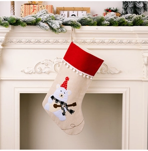 Detail of burlap Christmas stocking featuring a cartoon polar bear on a white fireplace