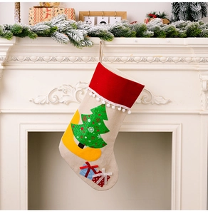 Close-up of Christmas stocking with tree design hanging on a white festive fireplace