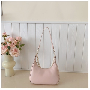Detail of pink half-moon shoulder bag featuring elegant white pearl bead strap accents