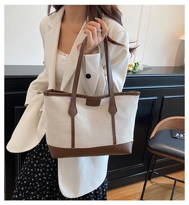 Detail showing high-quality canvas texture and brown leather trim on the tote bag