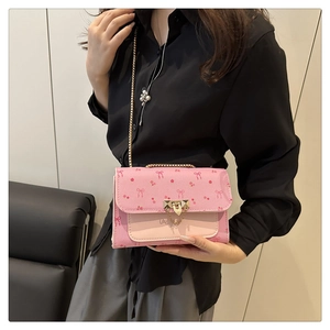 Détail du sac à fleurs rose avec bandoulière chaîne dorée et fermoir métallique