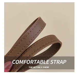 Detail shot of brown leather shoulder strap with high-quality stitching on a women's handbag