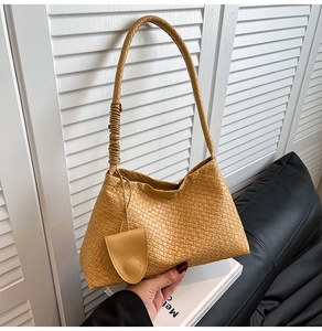 Détail du sac bandoulière tissé jaune avec petit accessoire de pochette ronde assortie