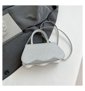 Detailed view of silver sequin handbag with unique wavy base and metallic handle