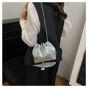 Detail of silver woven bucket bag featuring pearl charms and metallic chain strap