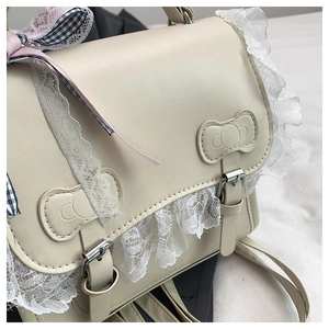 Gros plan sur le sac en cuir PU blanc crème avec bordure en dentelle et boucles nœuds