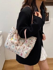 White pleated tote bag with cartoon bunny prints and plush toy charm on a shoulder strap