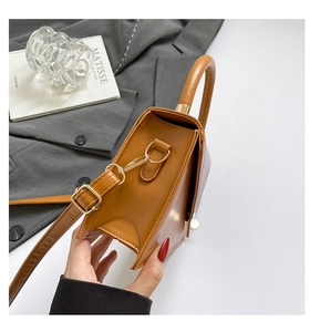 Detail of camel PU leather handbag featuring golden hardware and adjustable strap