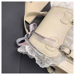 Vista dettagliata della borsa in ecopelle beige con pizzo bianco e nastro a quadri rosa