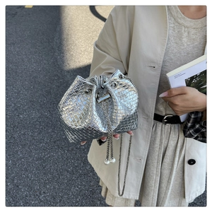 Detail of silver woven bucket bag with metallic chain strap and pearl accents