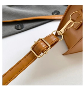 Macro shot of brown leather strap with adjustable gold buckle and fine stitching detail