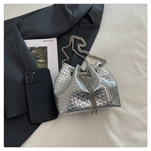 Detailed top view of silver woven bucket bag with metal chain and elegant accessories