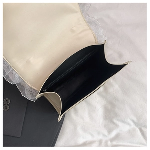 Vue détaillée de l'intérieur d'un sac crème avec dentelle et compartiment noir