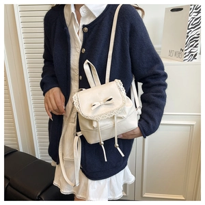 Close-up of ballet-core cream shoulder bag featuring delicate lace trim and bow detail