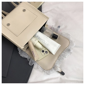 Dettaglio interno della borsa in pelle PU crema con chiusura magnetica e pizzo