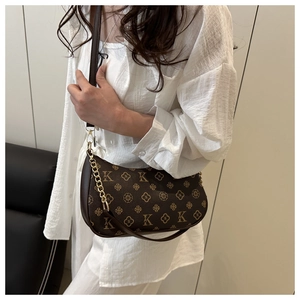 Detail view of a vintage dark brown monogram hobo bag with elegant gold chain strap