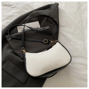 Détail du sac bandoulière contrasté noir et blanc en cuir grainé et boucles dorées