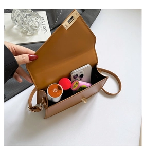 Brown leather crossbody bag interior showing storage for phone and cosmetics