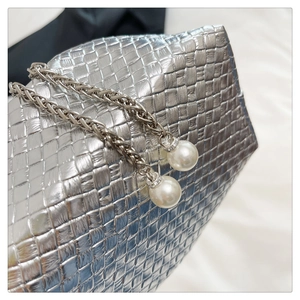 Detailed macro of silver woven texture purse with pearl and crystal chain accents