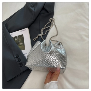 Detailed macro of silver woven bucket bag with metallic chain strap and pleated opening
