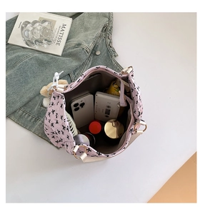 Spacious interior of pink bow print tote bag with phone, mirror, and portable fan inside
