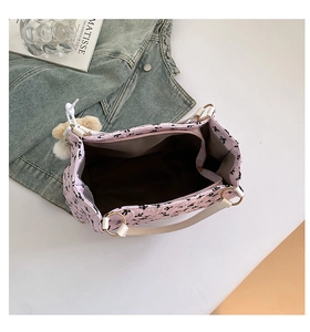 Top view of the interior space of a pink handbag with black bow prints and brown lining