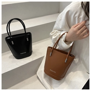 Detail of minimalist bucket bag showing smooth leather texture and fashion silver lettering