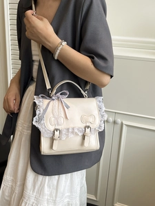 Borsa a tracolla Lolita bianco crema con pizzo e fiocchi indossata da una modella
