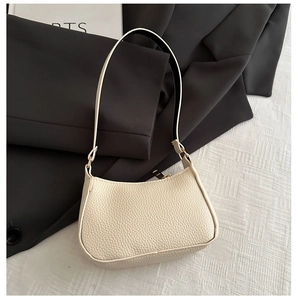Detailed shot of cream litchi grain faux leather underarm bag with metal zipper