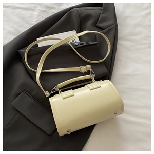 Detailansicht einer hellgelben Boston Bag mit silbernen Nieten auf grauem Blazer
