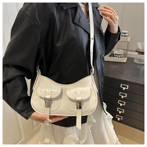 Detail of a white crossbody bag with twin flap pockets and silver buckles on model