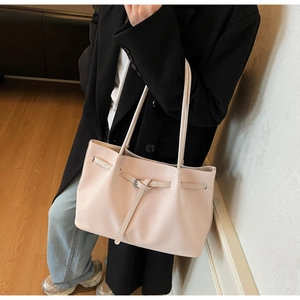Close-up of pink crossgrain leather tote bag with elegant buckle detailing and long straps