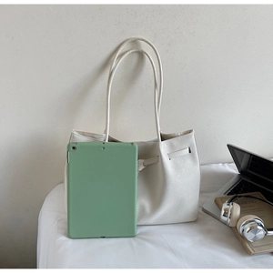 Detailed view of cream woven tote bag showing large capacity for laptop and tablet