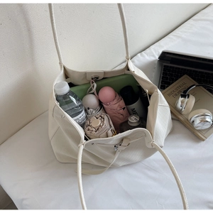 Detail of beige woven tote bag interior showing spacious storage for daily essentials