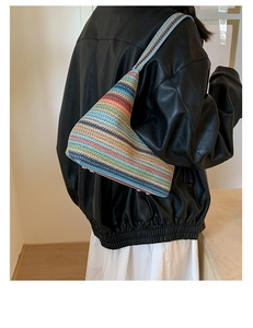 Detail of multi-color striped woven tote bag showing texture and reinforced bottom studs