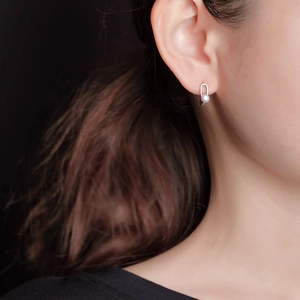 Minimalist U-shaped sterling silver pearl stud earrings shown on model for women