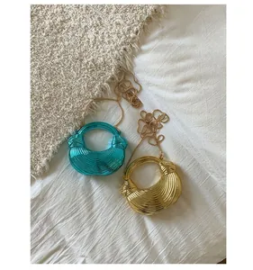 Detail of blue and gold shell-shaped evening clutch bags with spiral texture and chain